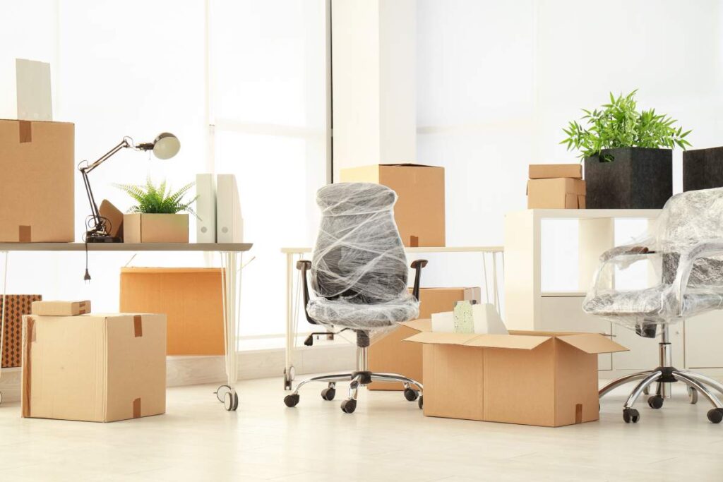 A family packs labeled boxes in a sunlit living room, preparing for a household move.